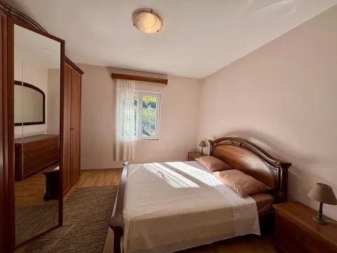 Furnished bedroom with a double bed, wooden wardrobe, and dresser with a mirror. - image 6