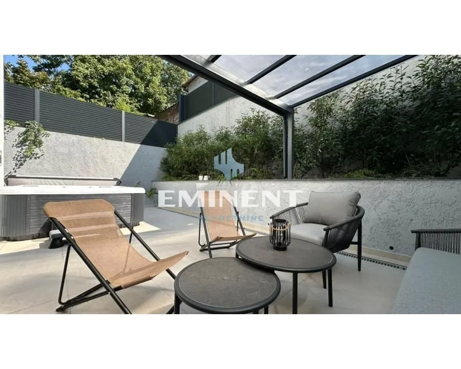 Furnished terrace with seating area and hot tub.