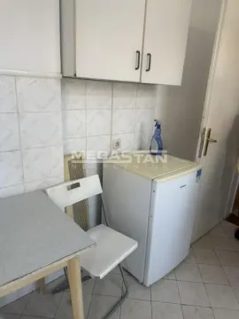 Manja kuhinja sa elementima, malim frižiderom i stolom sa stolicom. - image 6