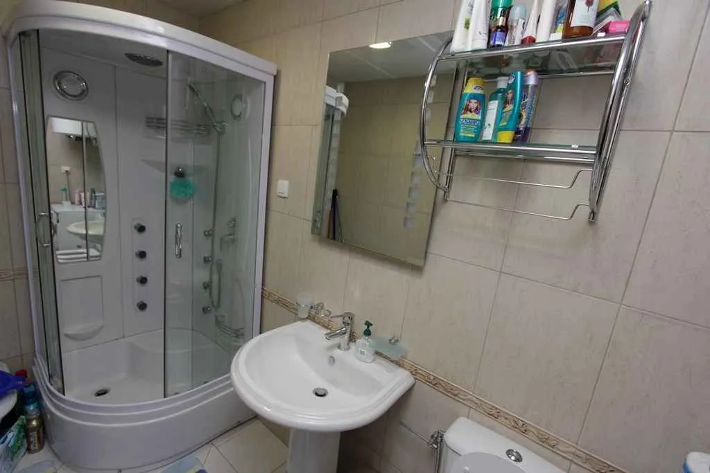 Bathroom with a shower cabin, sink, and mirror.