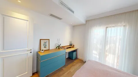 Svijetla spavaća soba sa plavom komodom, radnim stolom i velikim prozorom. - image 18