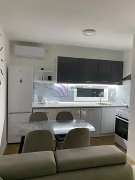 Kitchen with dining area equipped with white and dark cabinets and appliances. - image 11