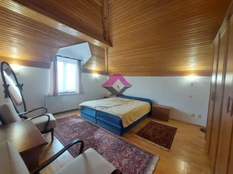 Spavaća soba sa bračnim krevetom, drvenim krovnim oblogama i tepisima. - image 18