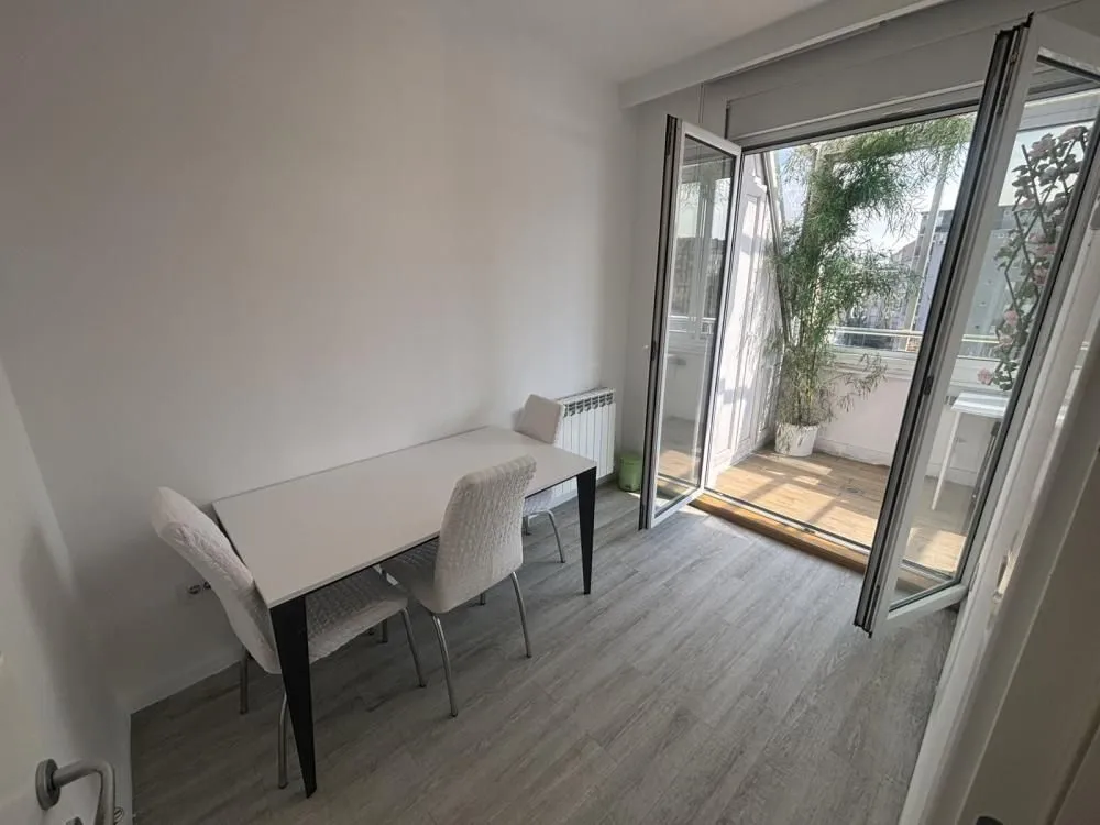 Dining area with a table and chairs and access to the terrace.