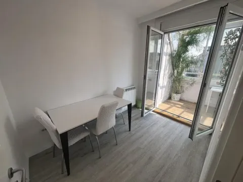 Dining area with a table and chairs and access to the terrace. - image 10