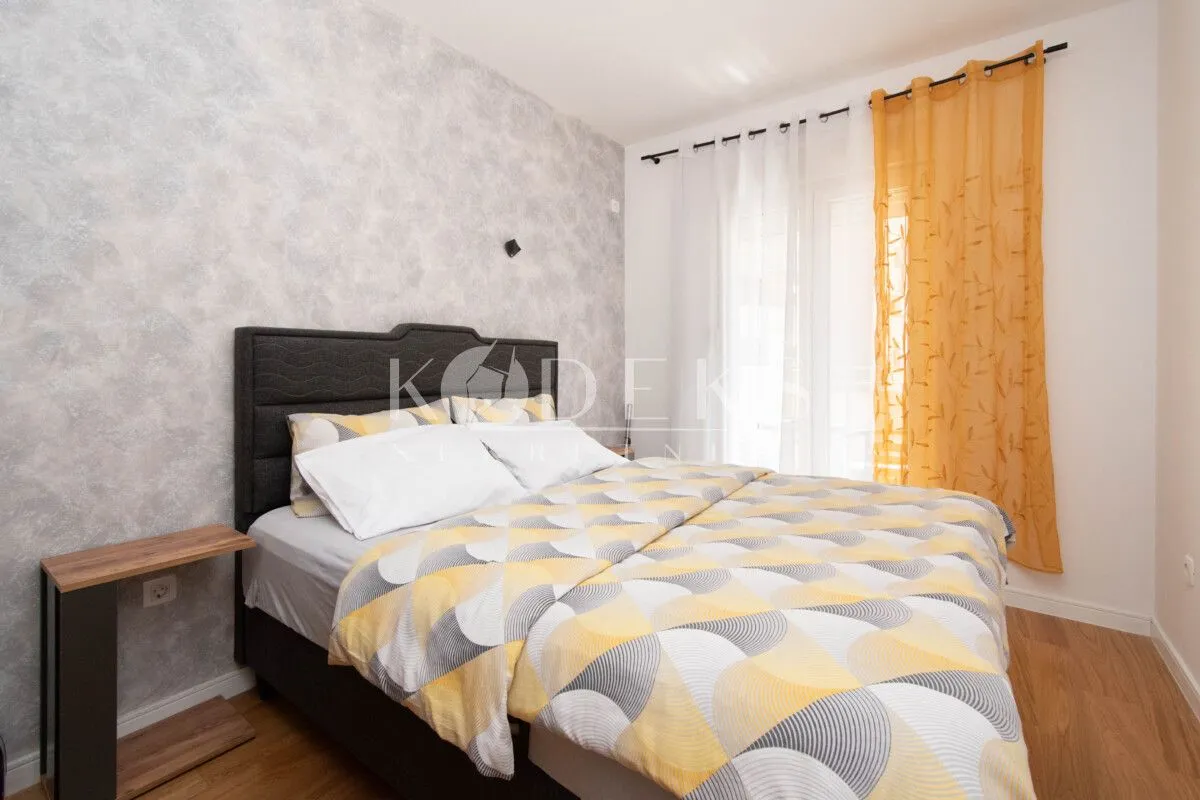 Furnished bedroom with a double bed and a window.