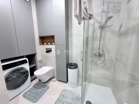 Moderno opremljeno kupatilo sa tuš kabinom, ugradnim elementima i veš mašinom. - image 13