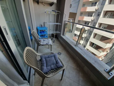 Namješten balkon sa stolicama i pogledom na zgrade u okruženju. - image 4