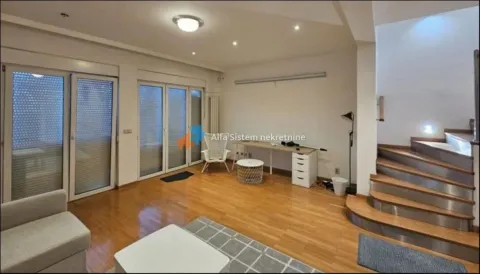 Spacious living room with wooden flooring, a desk, and stairs. - image 21