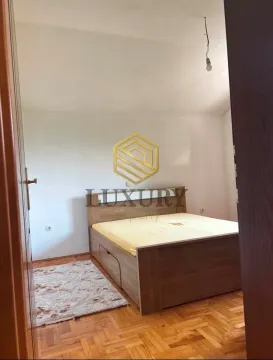 Spavaća soba sa bračnim krevetom i parketom na podu. - image 7