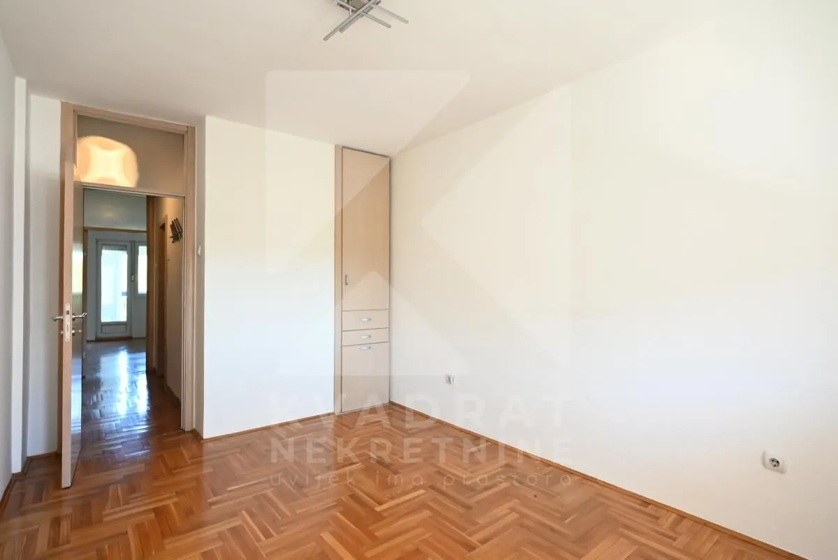Empty room with hardwood flooring and built-in closet.