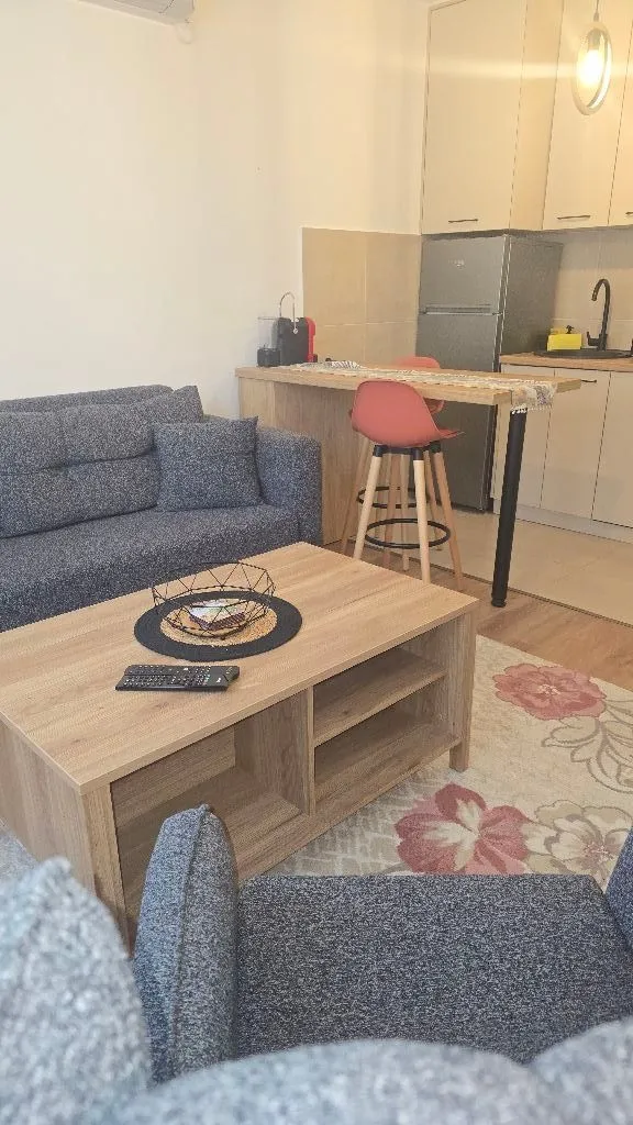 Dnevni boravak sa garniturom i trpezarijskim dijelom u pozadini.