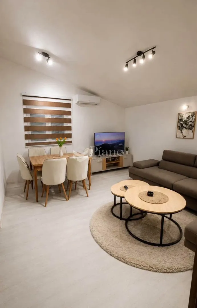 Living room with dining area, sofa and TV.