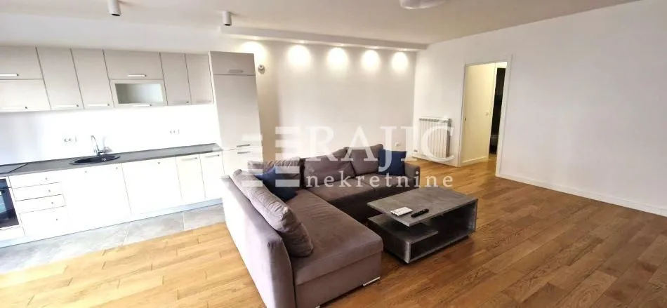 Spacious living room connected with the kitchen in bright tones.