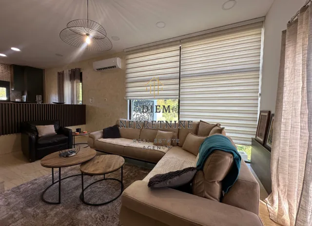 Spacious and bright living room with a sofa set and dining area in the background.