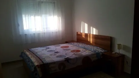 Namještena spavaća soba sa bračnim krevetom i prozorom sa bijelim zavjesama. - image 5
