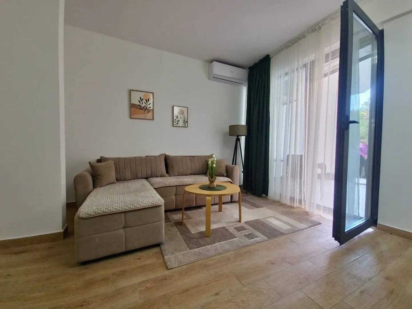 Living room with a sectional sofa, coffee table, and access to the terrace.