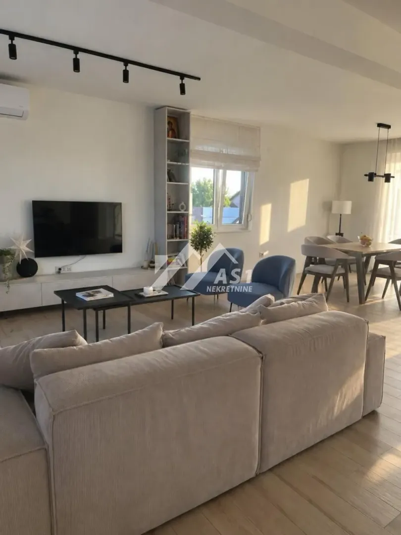 Spacious living room connected to the dining area with modern furniture.