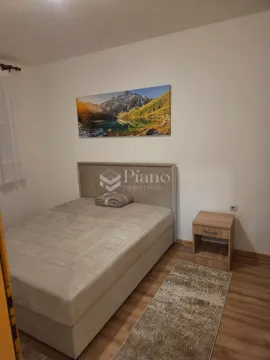 Spavaća soba sa bračnim krevetom, noćnim stočićem i slikom na zidu. - image 4