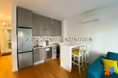 Compact kitchen connected to the living room and a dining table with chairs. - image 4