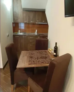 Manja kuhinja sa trpezarijskim stolom i braon elementima. - image 9