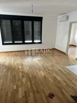 Empty room with parquet flooring and windows with closed shutters. - image 3