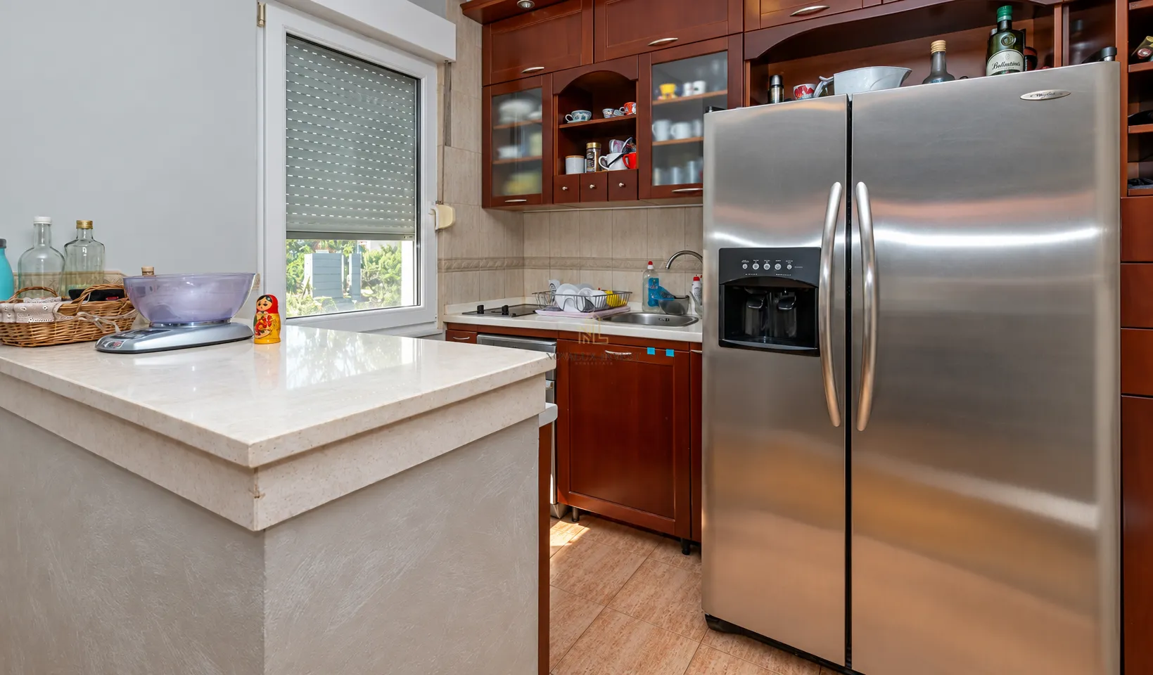 Kitchen with dark wooden cabinetry, countertop, and a large refrigerator.