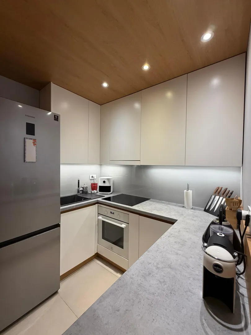 Modern and tidy kitchen with built-in appliances and a coffee maker.