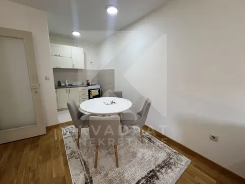 Dining area with a table and chairs and a view of the kitchen in the background. - image 3