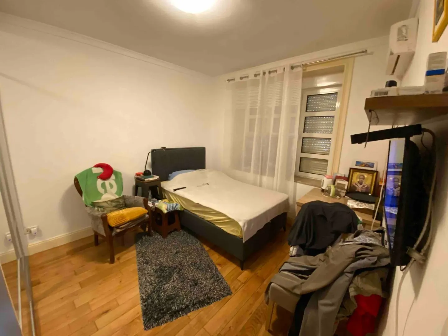 Manja spavaća soba sa krevetom i namještajem.