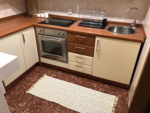 Small kitchen with wooden countertops, built-in oven, and sink. - image 10