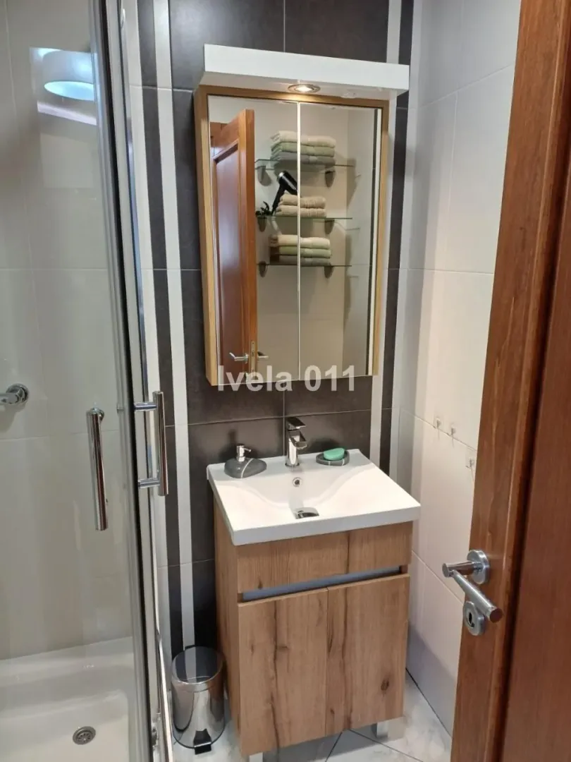 Bathroom with a vanity, cabinet, and shower enclosure.