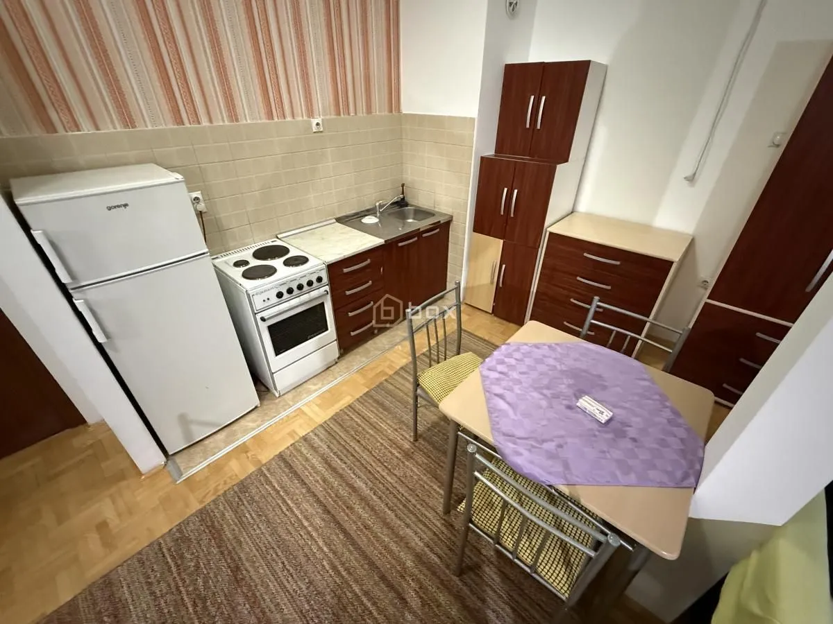 Smaller kitchen with a dining table and refrigerator.
