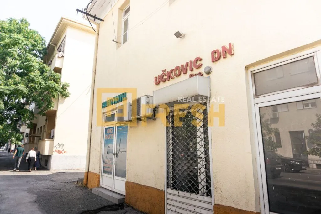Pogled na spoljašnjost poslovnog prostora sa ulazom i izlozima u prizemlju zgrade.