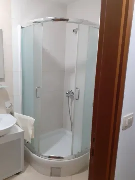 A simple bathroom with a semi-circular shower cabin. - image 7