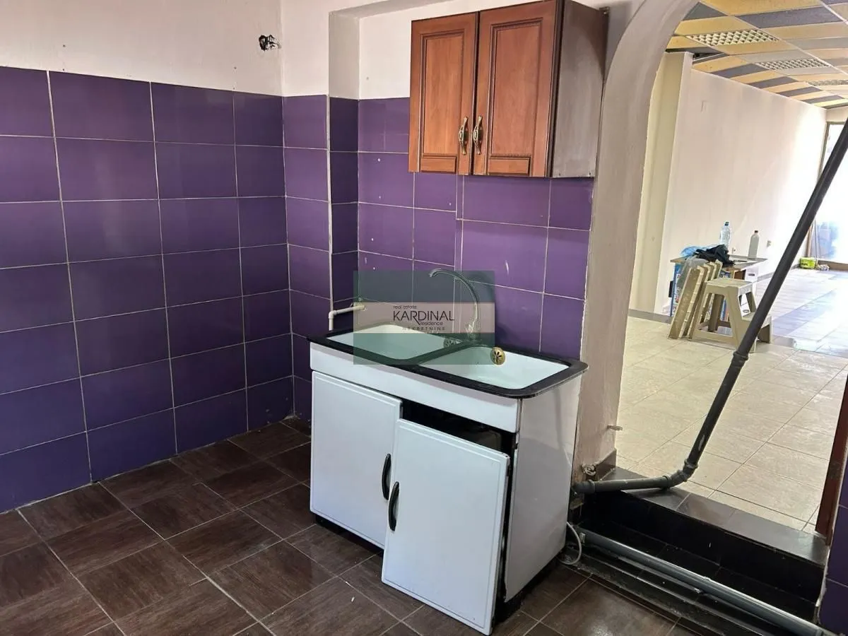 Small kitchen with a sink, cabinet unit, and wall tiles.