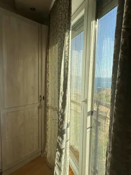 Spavaća soba sa ormarom i prozorom koji gleda na more. - image 12