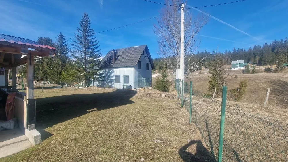Dvorište i eksterijer planinske kuće okružene prirodom.