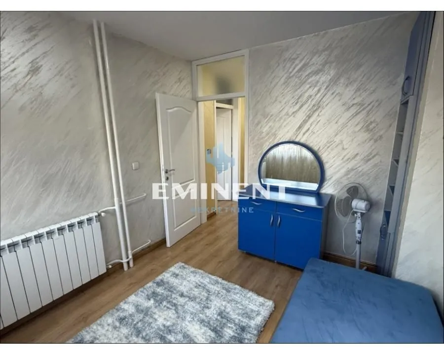 Small bedroom with a bed, dresser, and mirror.