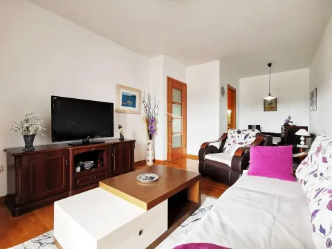 Bright living room with wooden furniture, a TV, and seating. - image 6