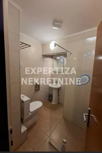 Small bathroom with a walk-in shower, washbasin, and toilet.
