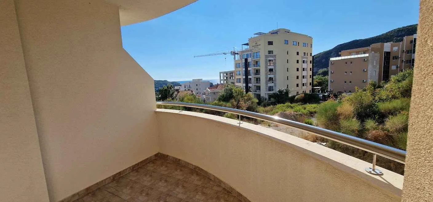 Manji natkriveni balkon sa pogledom na okolne zgrade i brda.