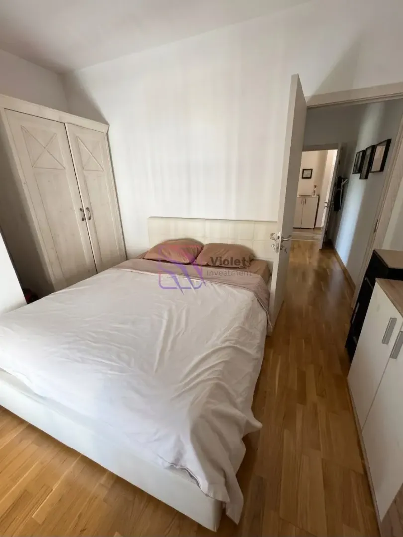 Furnished bedroom with a double bed, wardrobe, and wooden flooring.