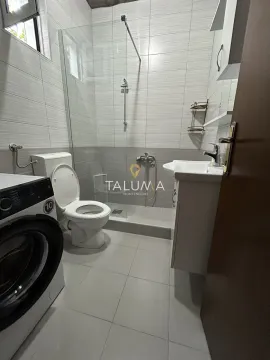 Small bathroom with a shower cabin, washbasin, toilet, and washing machine. - image 5