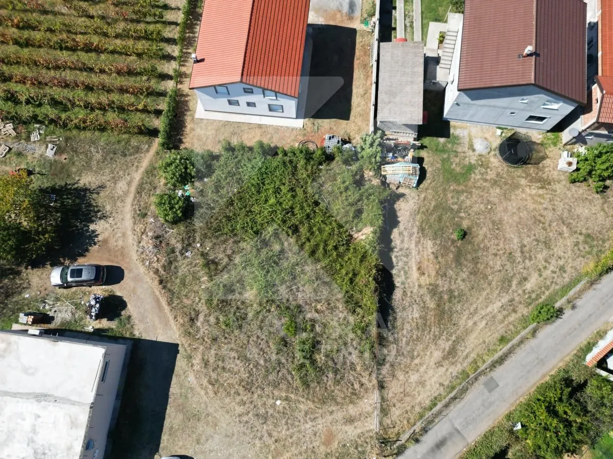 Pogled iz vazduha na plac sa kućama i okolnim dvorištem.