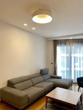 Living room with a sectional sofa and a coffee table. - image 3