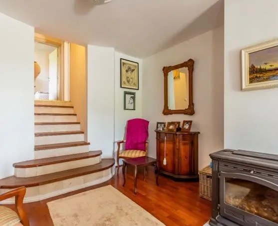 Living room with a fireplace, staircase, and wooden furniture.
