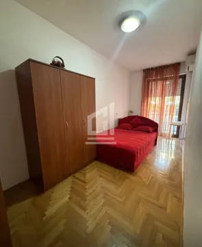 Spavaća soba sa bračnim krevetom, drvenim ormarom i parketom. - image 2