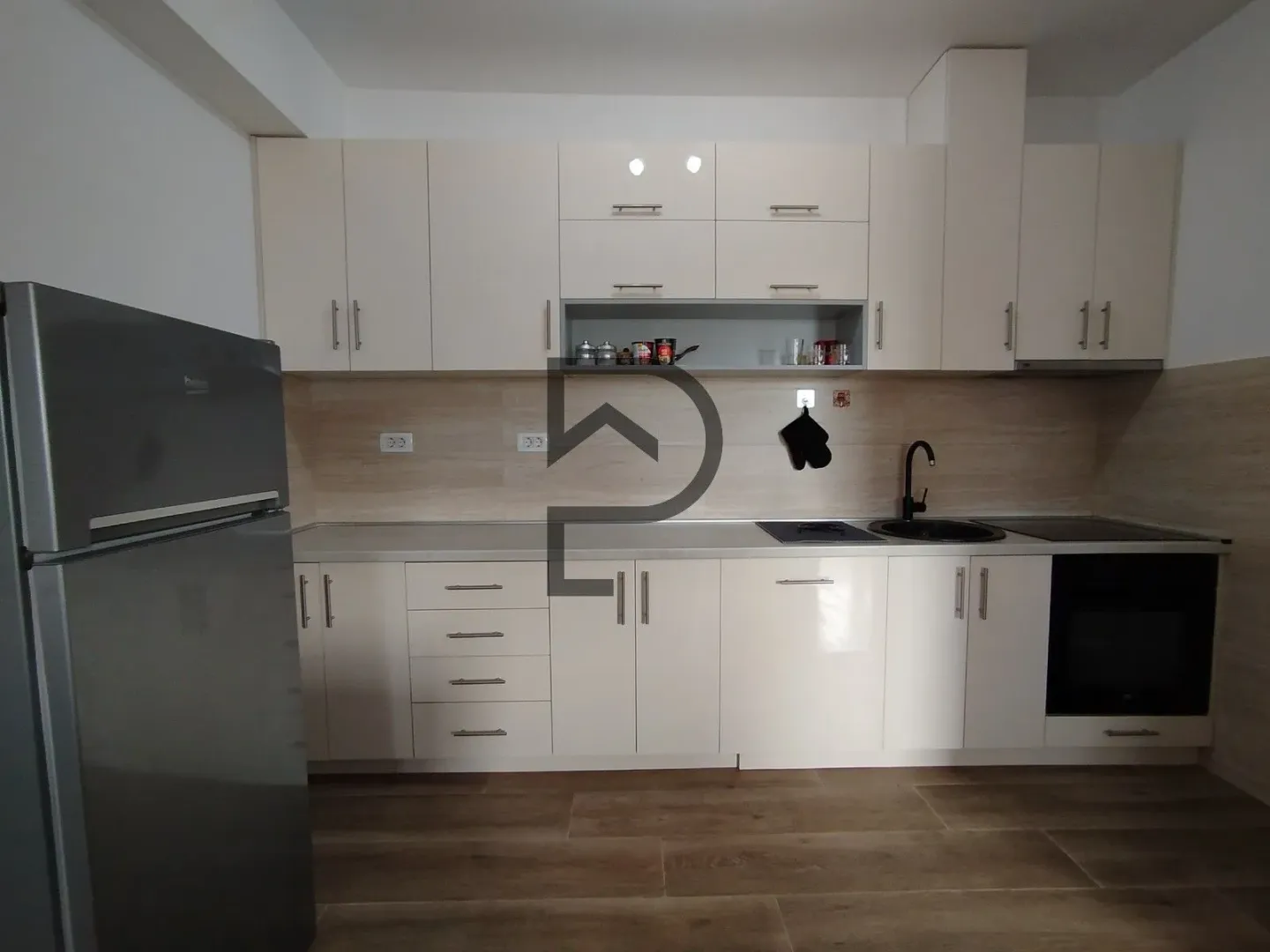 Modern kitchen with light cabinetry and built-in appliances.