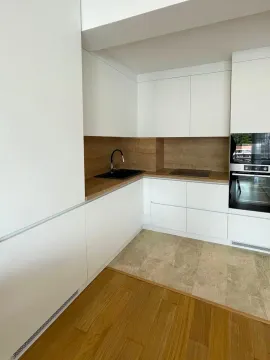 Moderna bijela kuhinja sa drvenim elementima i ugradnim uređajima. - image 2